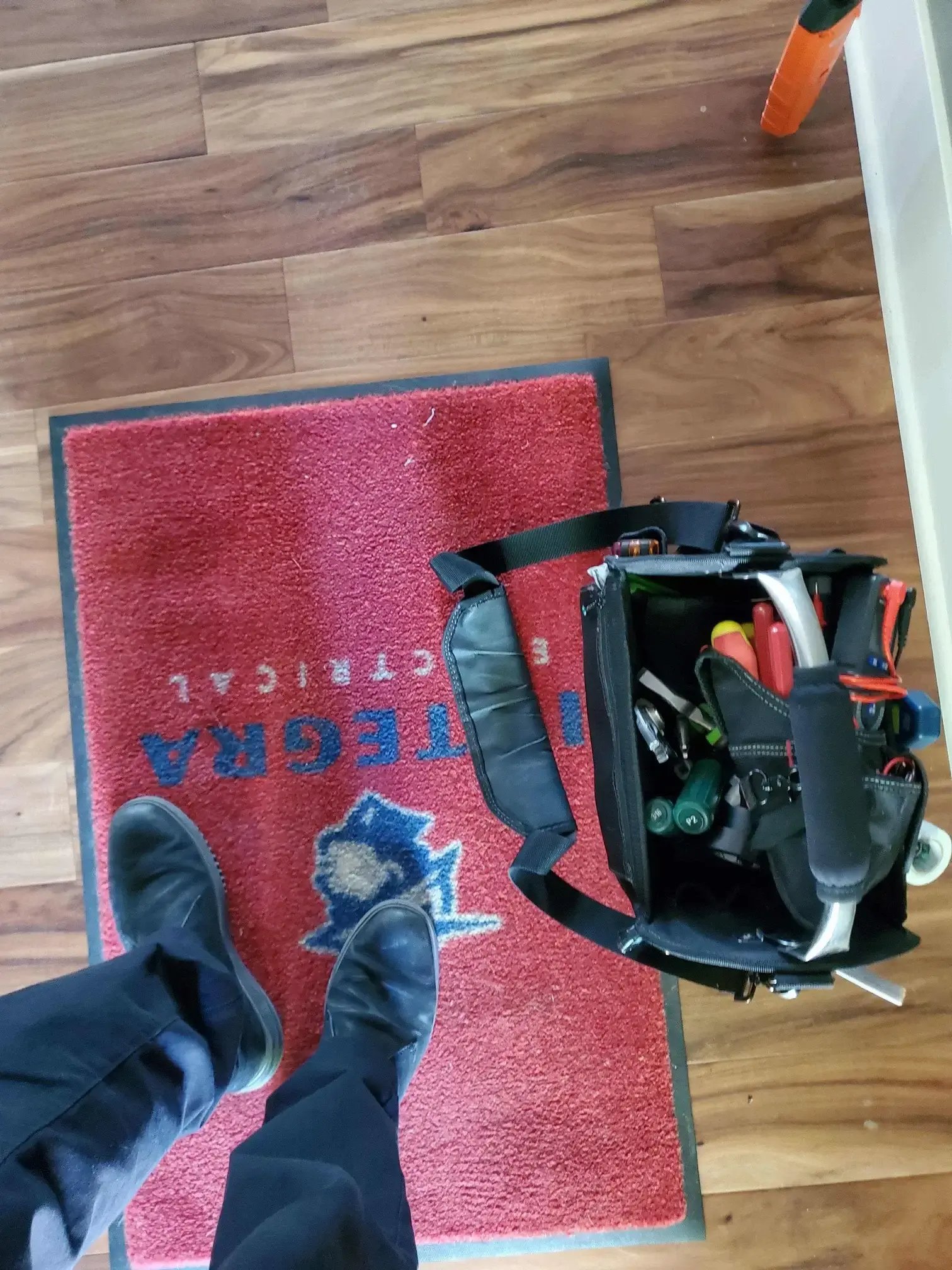 Electrician standing on Integra Electrical rug with his tools in a bag