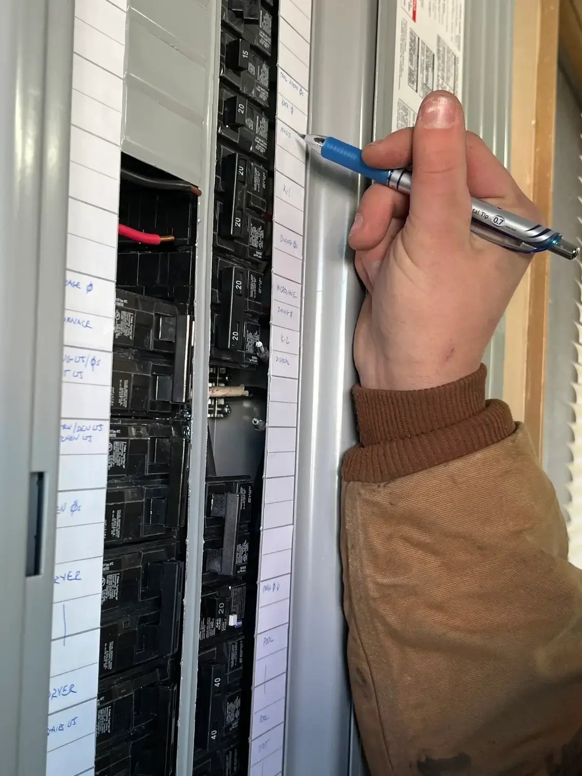 Man's hand examining electrical panel