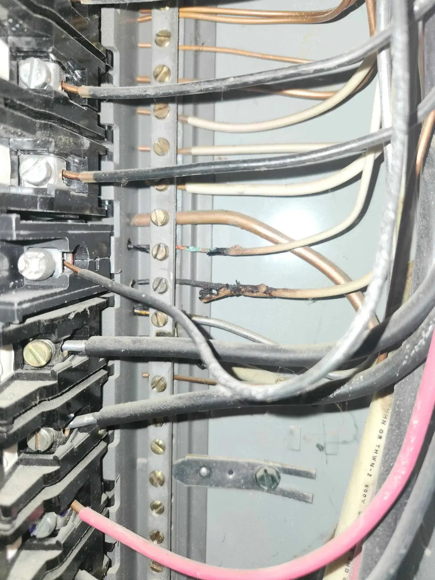 Burned wire in Des Moines Iowa electrical panel caused by heat damage.