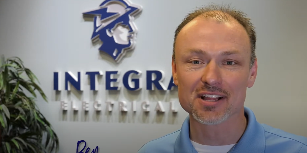 Man in blue shirt in front of integra logo