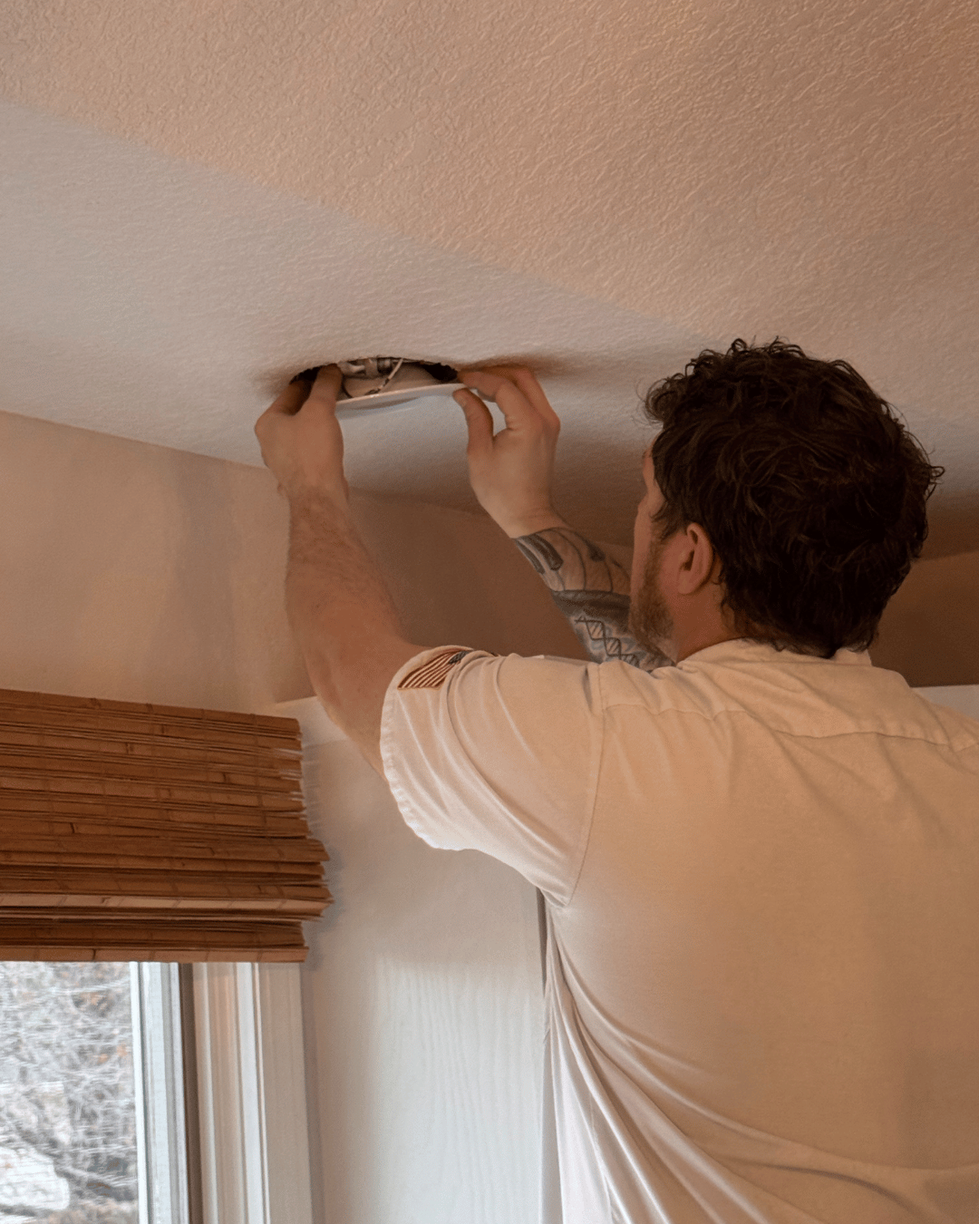 Electrician fixing a light fixture