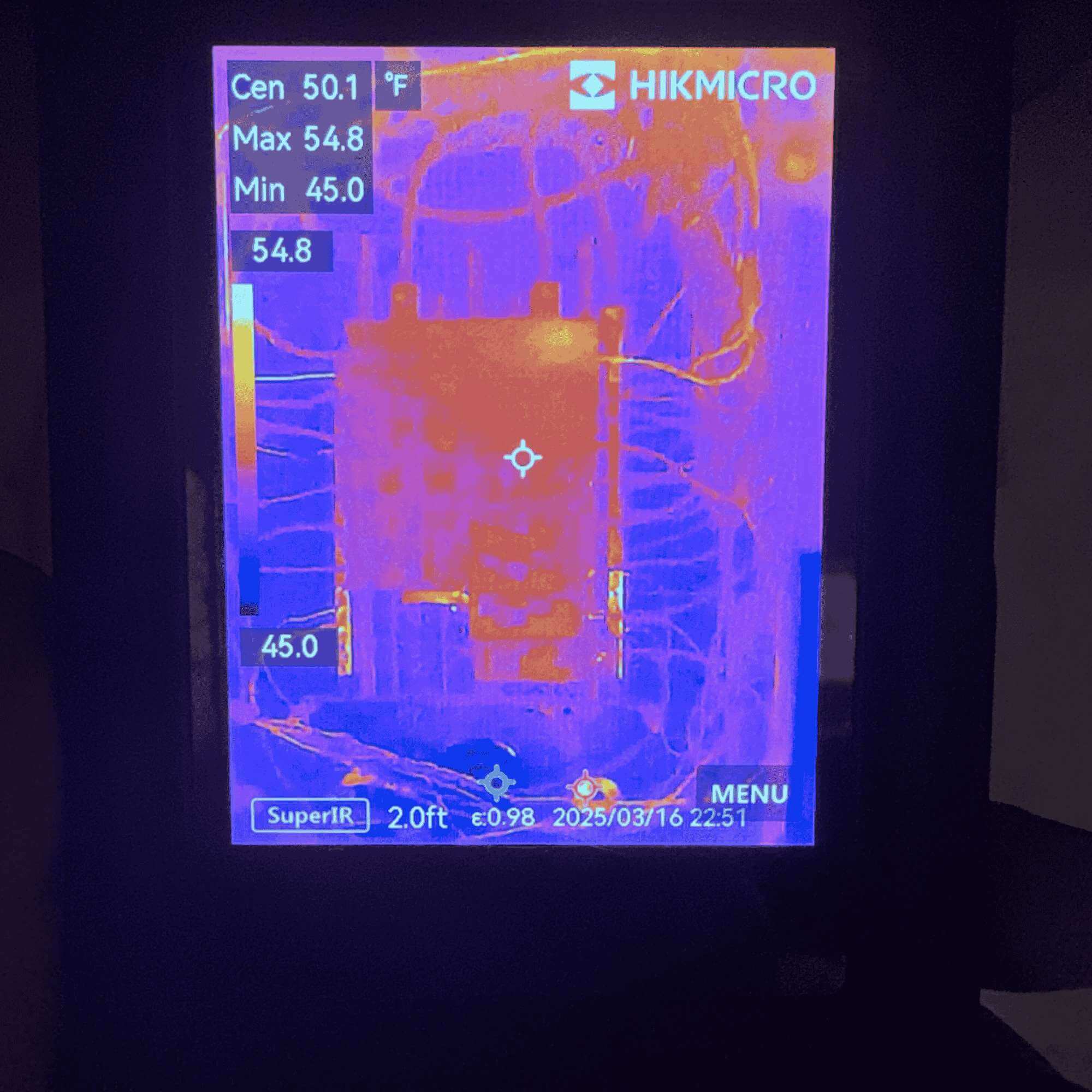 Thermal image of an electrical panel with temperature readings displayed on a HIKMICRO screen.