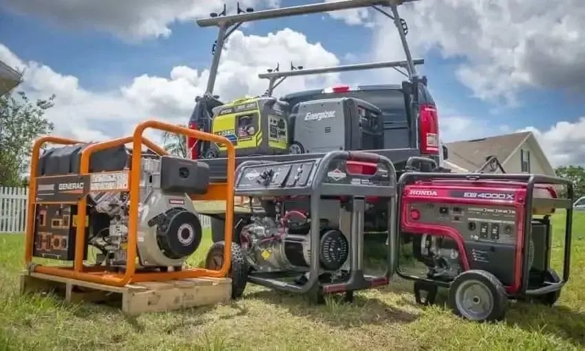 Various portable generators of different sizes and brands displayed outdoors near a pickup truck.