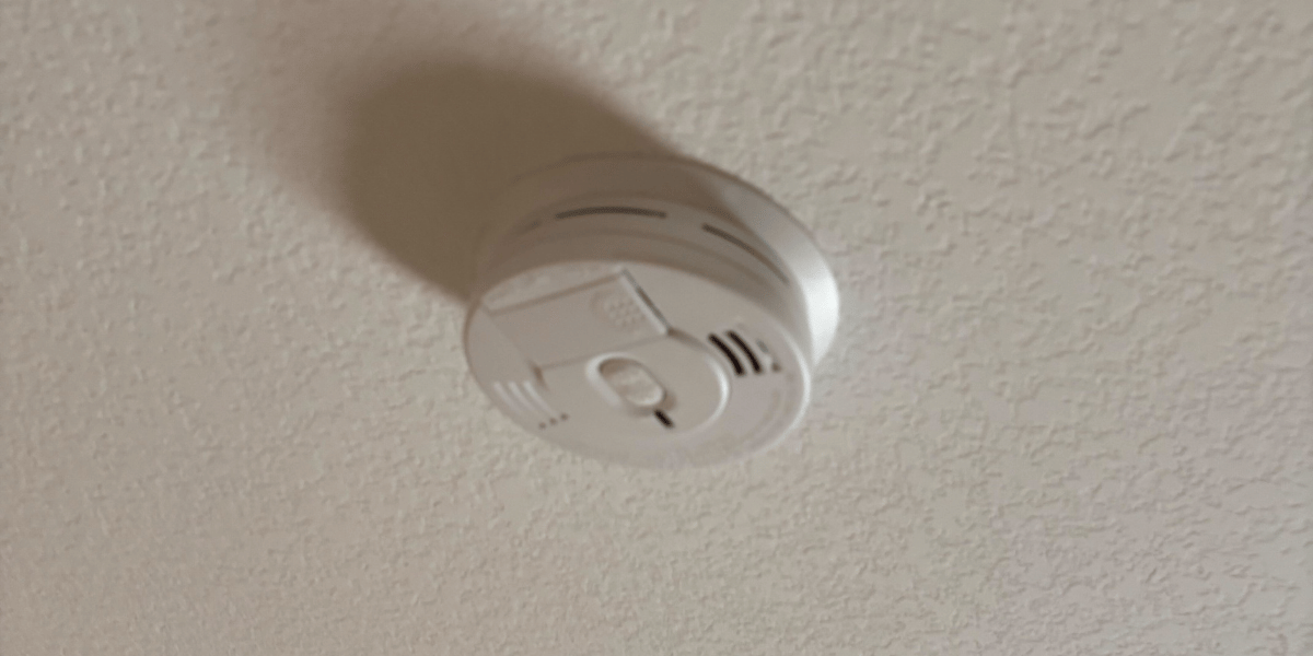 A smoke detector on a ceiling