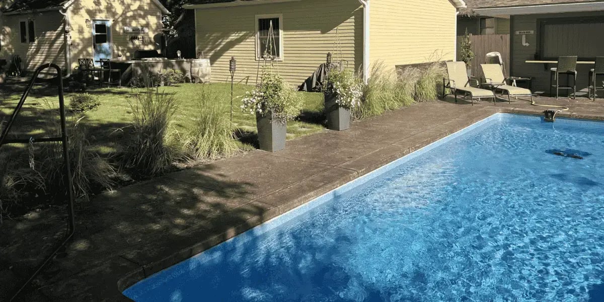pool in backyard, yellow house in background